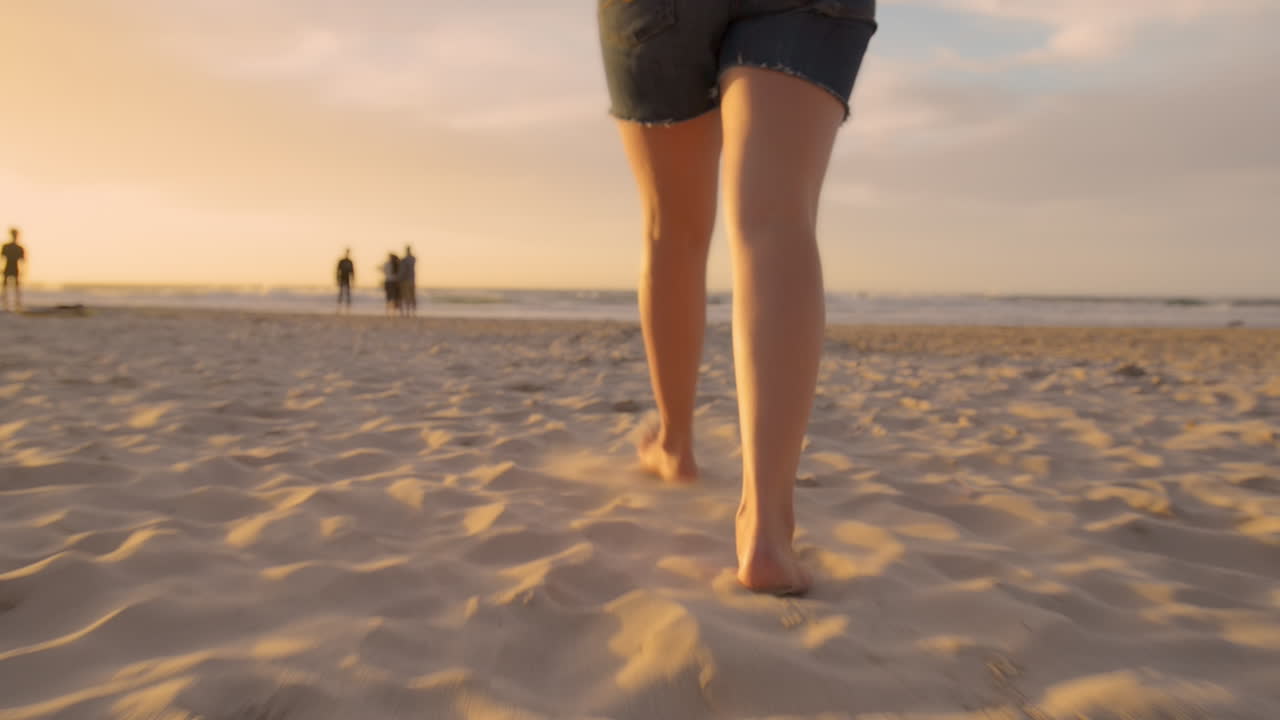 donna che cammina sulla spiaggia a piedi nudi al tramonto steadicam shot