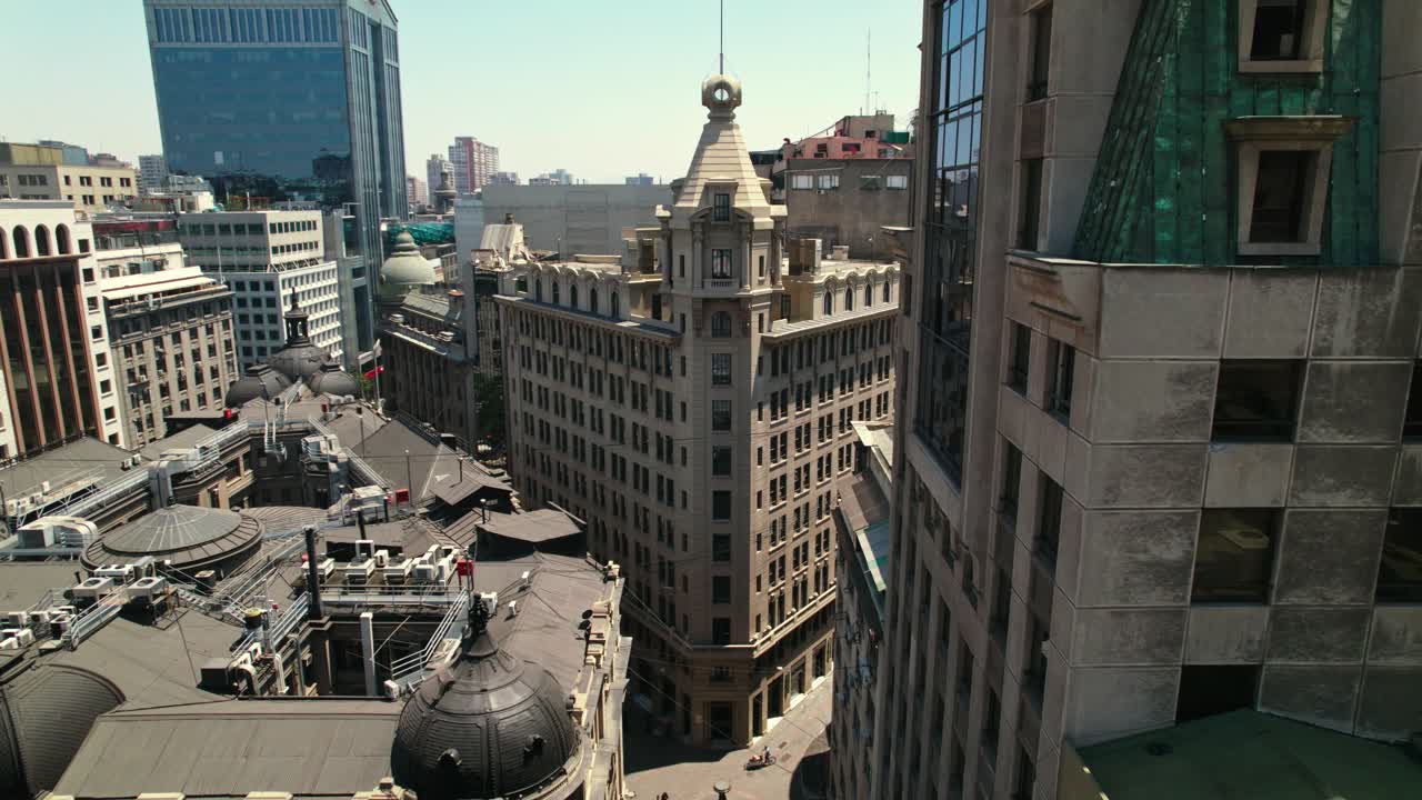 Flyover establishing over La Bolsa neighborhood with the Arizt&iacute;a Building on a sunny day in the financial center of Santiago Chile