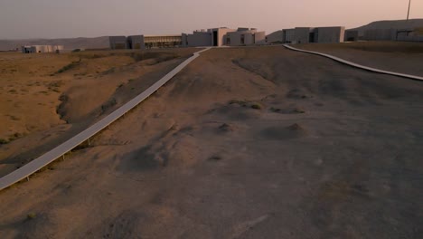 drone shot flying towards the mud volcanoes tourism complex in the qobustan national park in azerbaijan at sunset while panning up