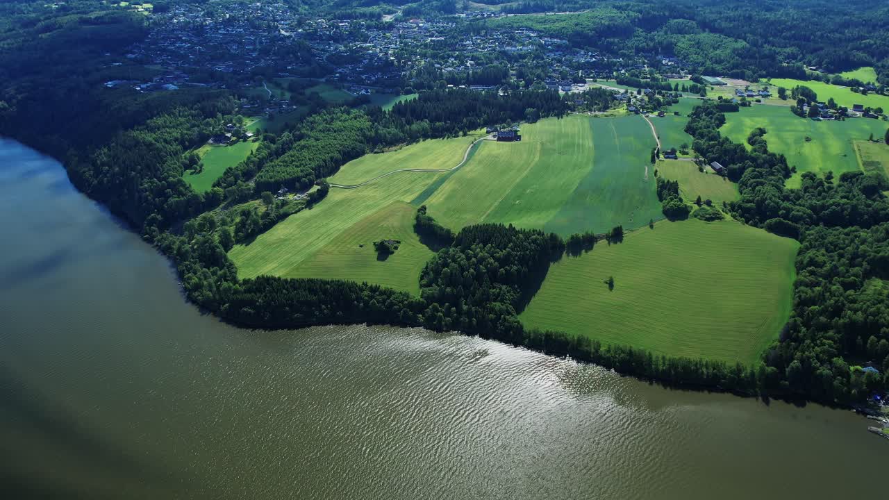 Drone view of scenic Norway landscape showcasing green fields and river