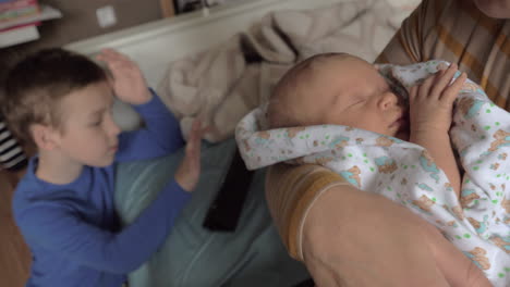 grandma with grandchildren at home she rocking baby granddaughter in arms