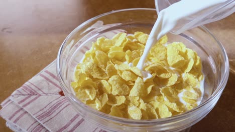 Crispy-yellow-corn-flakes-into-the-bowl-for-the-morning-a-delicious-Breakfast-with-milk.-Slow-motion-with-rotation-tracking-shot.