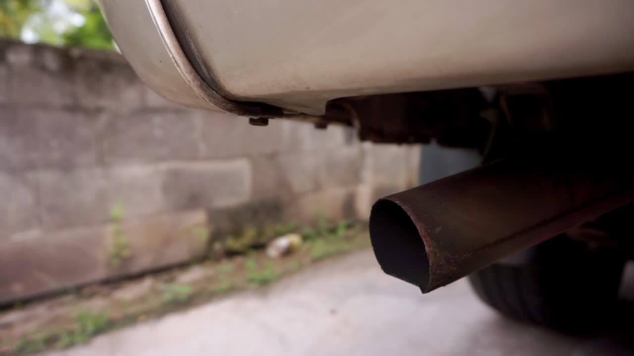 Close up shot of Exhaust Gases From The Muffler of Running Car.Low angle close up.Save the earth.Environment pollution and climate change.