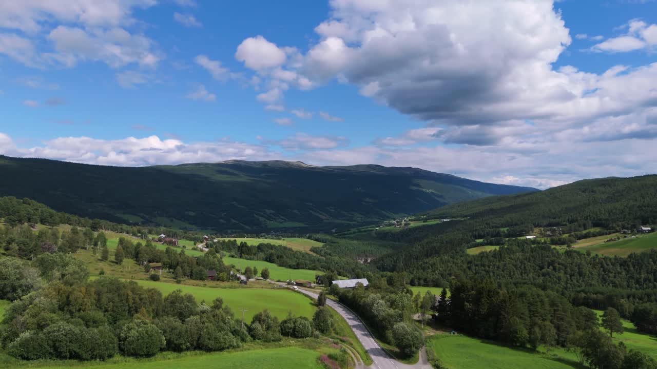 노르웨이 인네르덴 펠리케 (innlandet fylke) 에 있는 푸른 숲과 멀리 있는 산들로 둘러싸인 그림 같은 계곡의 아름다운 공중 풍경