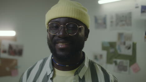 close-up portrait of a black man in a beanie and glasses