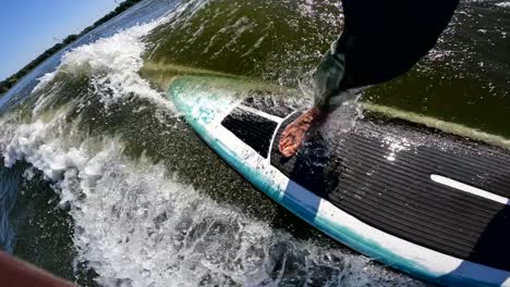 surfer on longboard in wave behind boat making switch