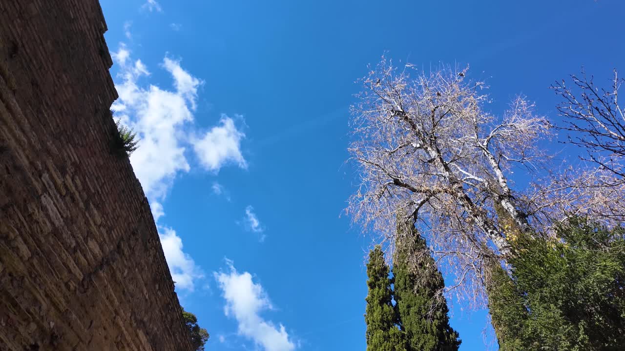 Static contemplative shot of the clear sky on a bright morning at the monumental complex of the Alhambra in Granada, Spain