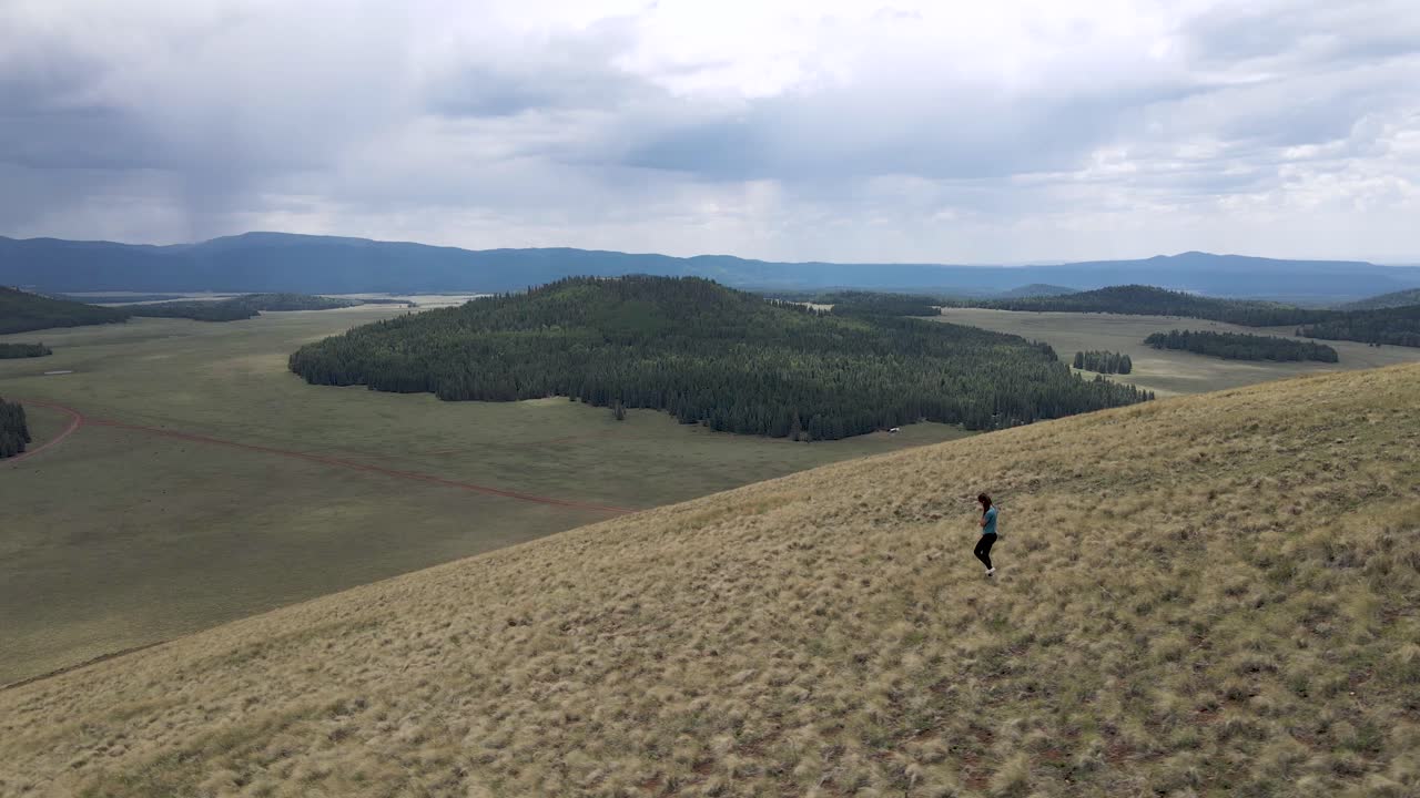 공중: 광야에서 산비탈을 내려가는 여성 등산객, 보기를 따르십시오.