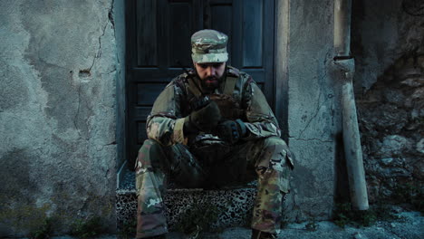 soldier sitting near a ruin communicates with his team