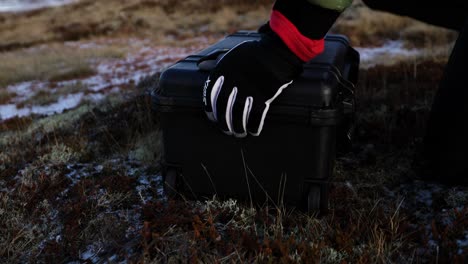 adventure camera guy setting down hard flight case filled with gear, opening up