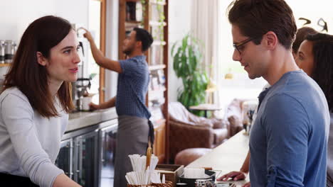 Young-customers-queuing-to-order-at-a-coffee-shop-counter