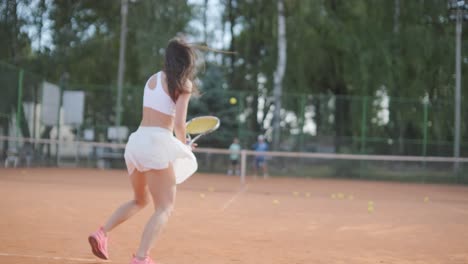 female tennis player practicing serve on outdoor court