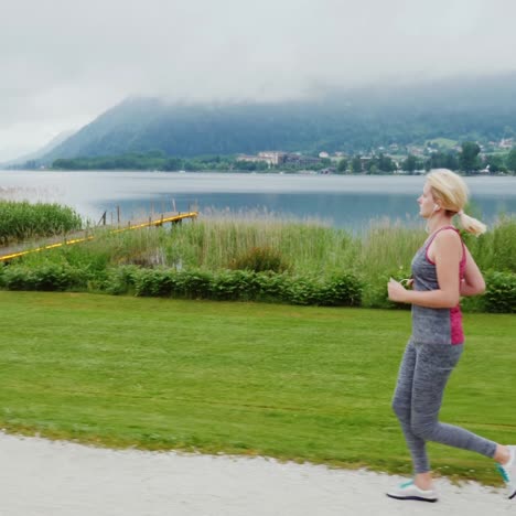 steadicam shot: morning jog in a picturesque place amid the alps mountains near a beautiful mountain lake