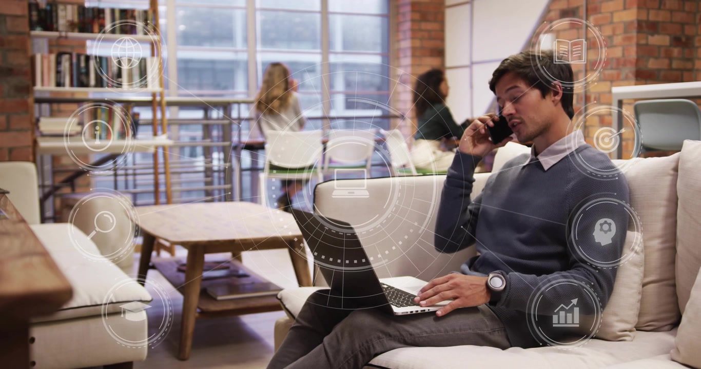 Giovane professionista che lavora al laptop e allo smartphone in un ufficio moderno