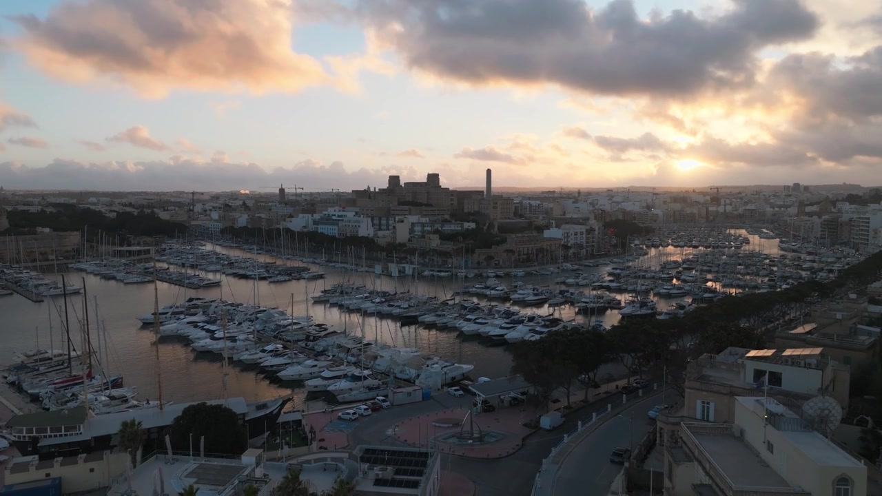 Pemandangan Matahari Terbenam Pelabuhan Besar di Valletta, Malta Dengan Garis Langit Bersejarah dan Marina Lokal. Foto Udara