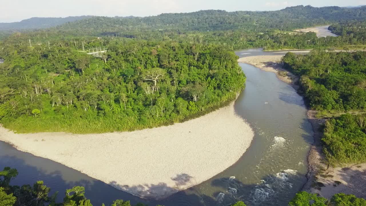 majestuoso río rodeado de densos bosques y pequeñas montañas, vista aérea de drones
