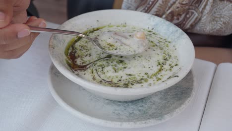 person eating yogurt soup
