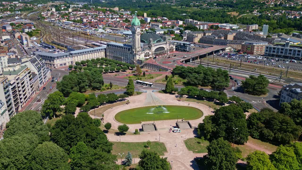 High-altitude drone fly towards the Limoges-Bénédictins railway station with Champ de Juillet public park, Limoges, Haute-Vienne, France
