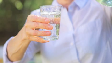 mid section of senior woman pouring lemonade from a jug