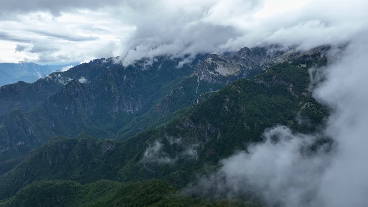 Aerial cloudscape, drone fly close to clouds in Albanian green Theth mountain landscape, National Park environment