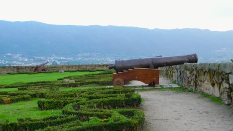 old fashioned cannon on wooden mounting wheels on top of battlement parapet on castle overlooking chaves vila real portugal