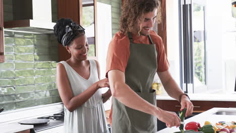 diverse couple, a young african american woman and a young caucasian man, cooking together at home