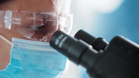 científico mirando a través del microscopio