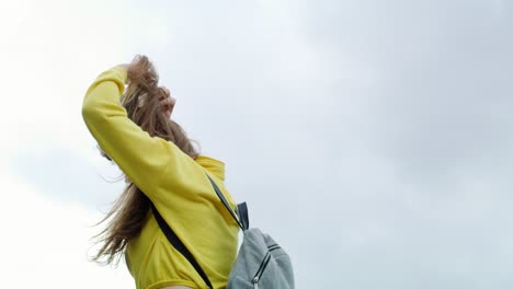 Tilt-down-view-of-joyful-young-woman-walking-in-the-city