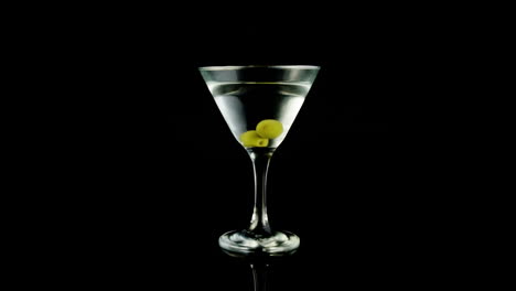 video de un vaso de martini sobre un fondo negro