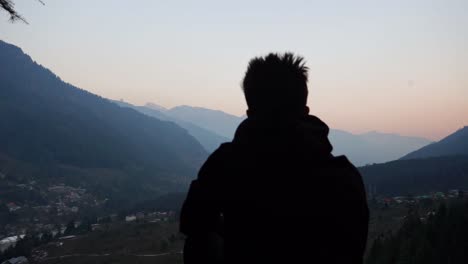 silueta de persona en la cima de la montaña con vistas a la ciudad himalaya de manali en india