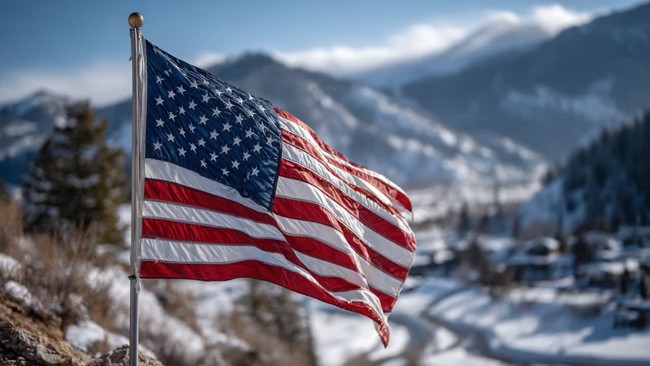 Una maestosa bandiera americana sventola orgogliosamente sullo sfondo di una montagna innevata, a simboleggiare la libertà e l'unità in un pittoresco paesaggio invernale