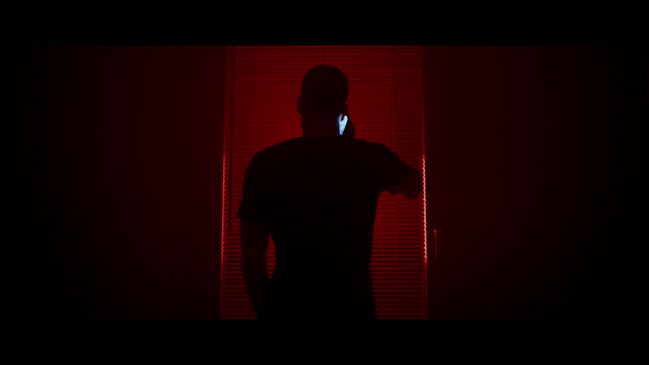 Man Talking on Phone in Red Light