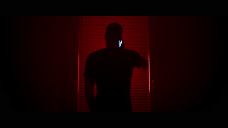 man talking on phone in red light
