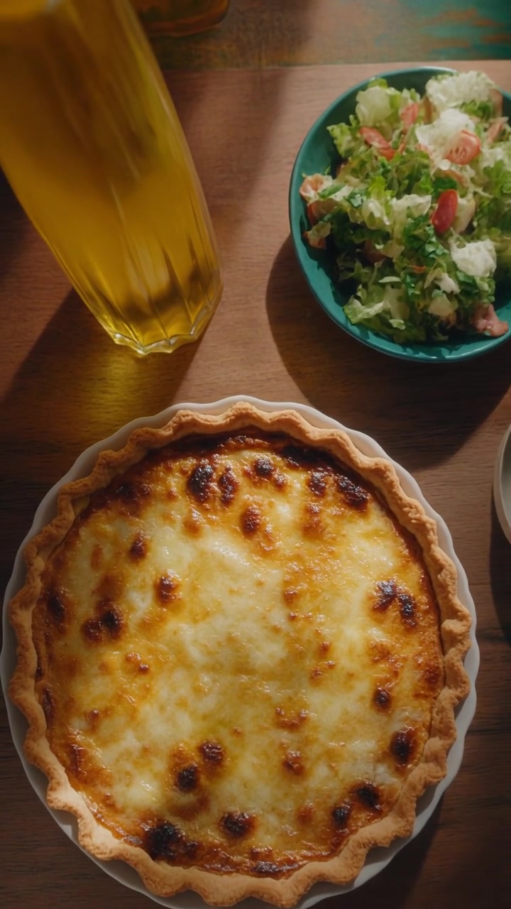 Quiche appena sfornata con insalata di contorno su tavolo di legno