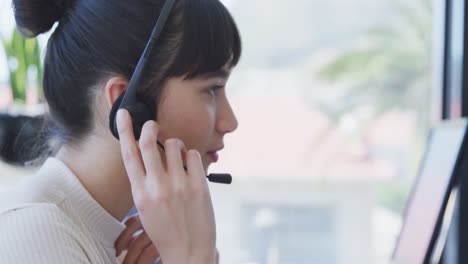 young woman with headset working on computer