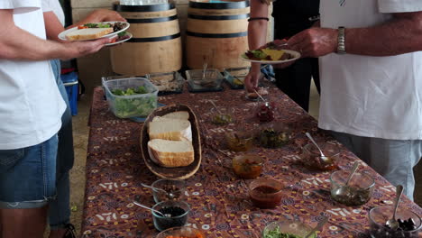 gente en una mesa de buffet llena de degustaciones de comida vegana y saludable