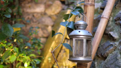 vintage lantern hanging from bamboo pole in garden