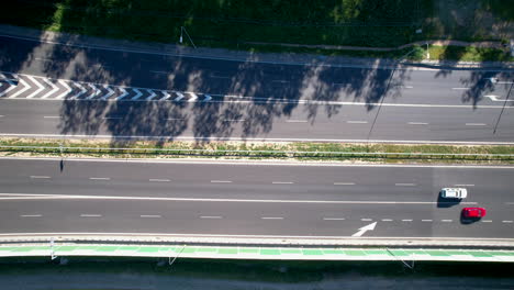 overhead view of vehicles driving through the asphalt lanes of highway