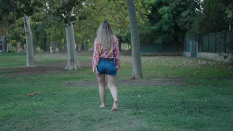 woman walking barefoot in a park