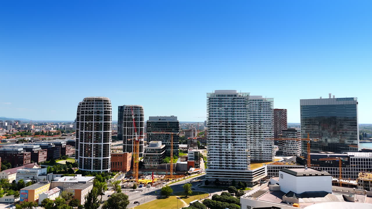 Summer skyline of Bratislava. Bratislava's skyline features modern architecture and construction under clear blue skies during a sunny summer day