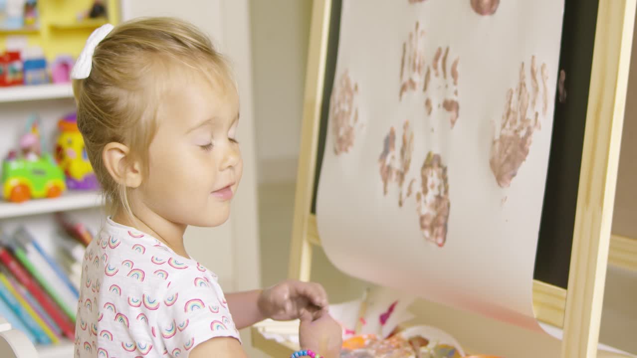 행복하고 매력적인 작은 금발 소녀 예술가