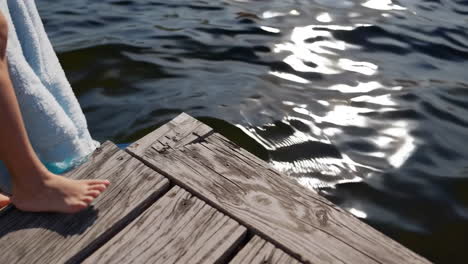 barefoot on a wooden dock by reflecting water