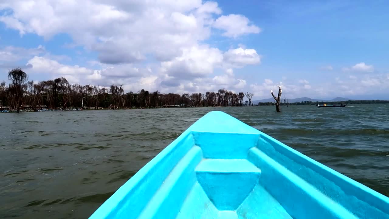 vista panorámica desde un pequeño bote azul que flota en el lago naivasha, kenia