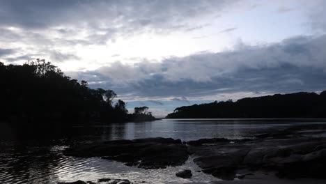 Lapso-De-Tiempo-De-Nubes-Moviéndose-Sobre-Una-Tranquila-Bahía-Oceánica-En-La-Costa-Sur-De-Nsw