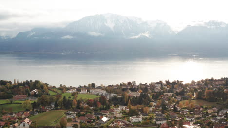 Jib-down-of-beautiful-Swiss-town-located-near-a-large-lake-and-mountains