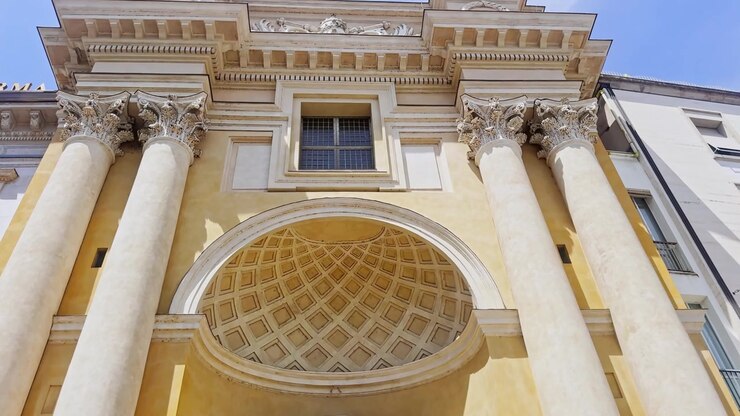 Ripresa dal basso dall'ingresso di San Pietro Apostolo verso l'elegante facciata neoclassica, le colonne corinzie e i dettagli decorati della parte superiore a Parma, Italia