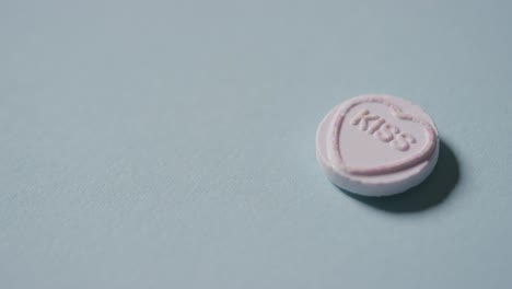 파란색 배경에 낭만적인 메시지 사랑으로 심장 사탕을 손에 들고