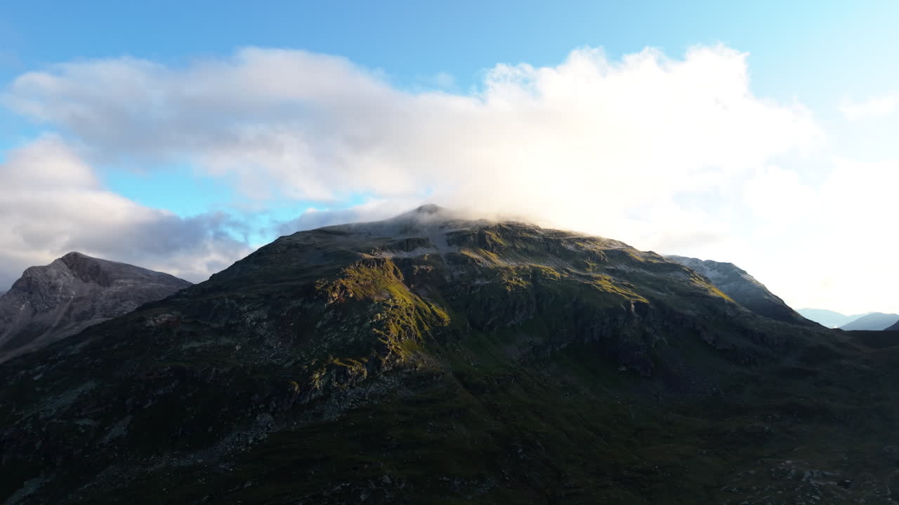 Scenic aerial view of Swiss Alps at sunrise with soft clouds