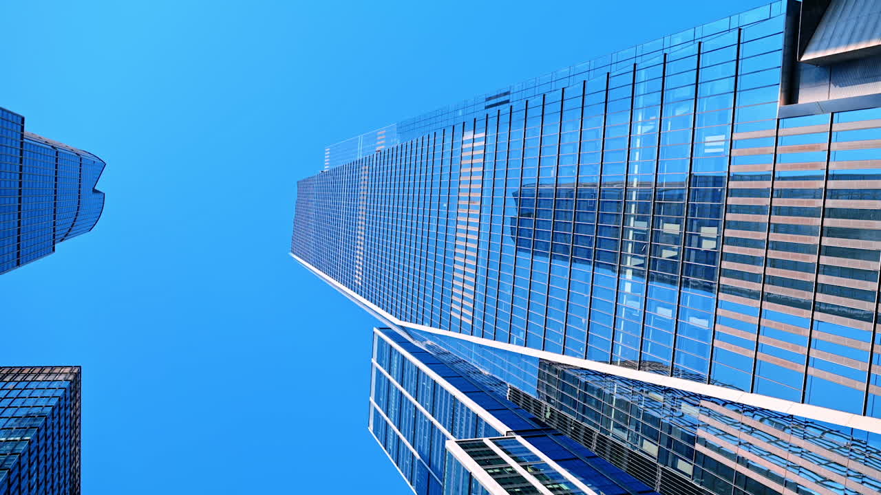 Majestic skyscrapers reflecting blue clear sky. Low angle view at the high-rises of New York, USA