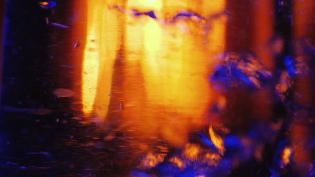 el agua hierve en un hervidor eléctrico retroiluminado un fuego en el fondo arde en el fondo